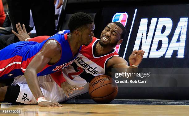 Reggie Jackson of the Detroit Pistons and John Wall of the Washington Wizards go after a loose ball in the second half at Verizon Center on March 14,...