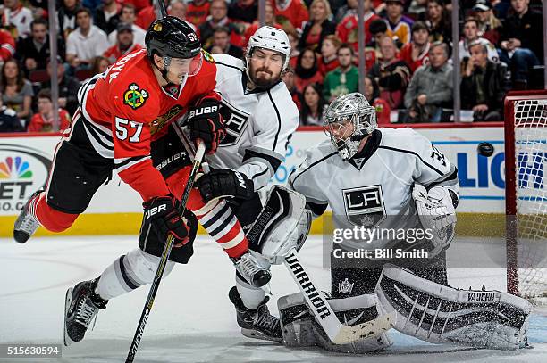 Trevor van Riemsdyk of the Chicago Blackhawks and Drew Doughty of the Los Angeles Kings get physical as the puck flys past goalie Jonathan Quick in...