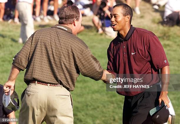 Golfer Tiger Woods of the US shakes hands with fellow countryman Bob May after their final putts on the 18th hole 20 August 2000 to force a playoff...