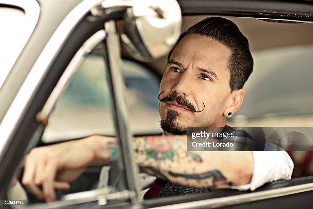 Man with moustaches sitting  in car