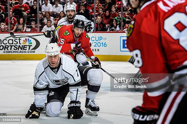 Artem Anisimov of the Chicago Blackhawks watches for the puck in between Rob Scuderi and Drew Doughty of the Los Angeles Kings in the third period of...