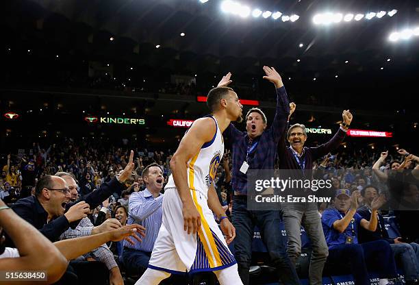 Fans react after Golden State Warriors made a three-point basket against the New Orleans Pelicans at ORACLE Arena on March 14, 2016 in Oakland,...