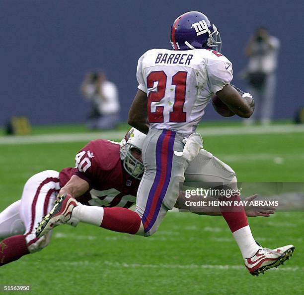 New York Giants' Tiki Barber evades the grasp of the Arizona Cardinals' Pat Tillman to run for a 78-yard touchdown in the second quarter of their...