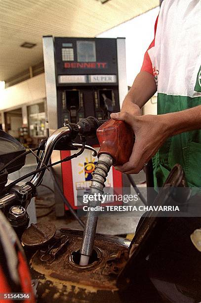 Gasoline vendor in San Jose, Costa Rica, 08 September 2000, fills a motorcycle tank. AFP PHOTO / Teresita CHAVARRIA Un vendedor provee gasolina en...