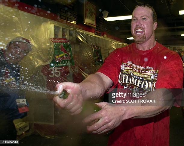 St. Louis Cardinals player Mark McGwire sprays champagne on teammates after they beat the Houston Astros and won the National League Central Division...