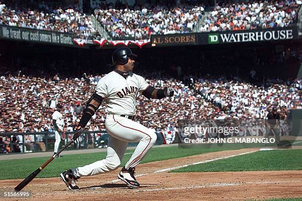 San Francisco Giants slugger Barry Bonds follows through with an RBI triple off New York Mets starting pitcher Mike Hampton during the third inning,...