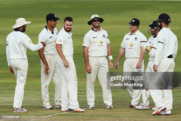 Jon Holland of the Bushrangers celebrates with team mates after taking the wicket of Sean Abbott of the Blues during day one of the Sheffield Shield...