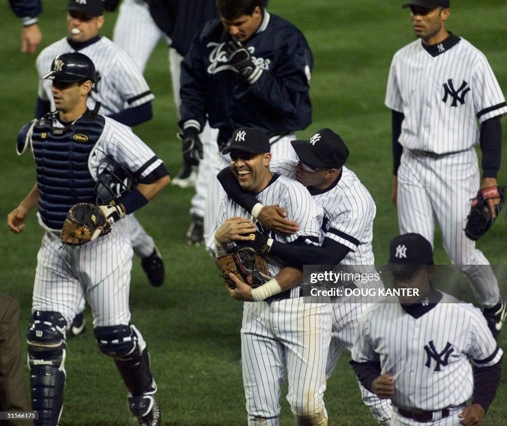 New York Yankees Luis Sojo (C) gets a hug from Jos