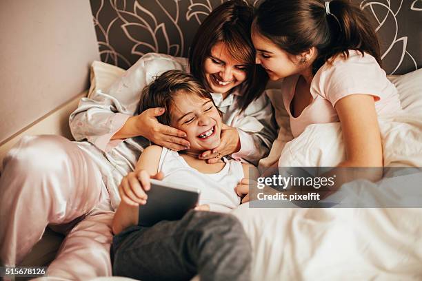 morgen lächelt - boy in pajamas and mom on tablet stock-fotos und bilder