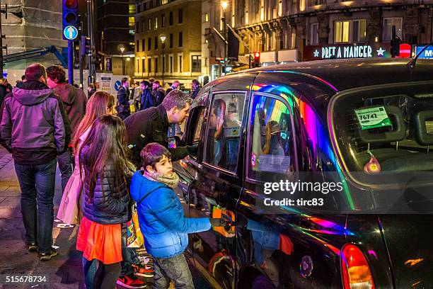 family of four hailing a london cab - taxi boys stock pictures, royalty-free photos & images