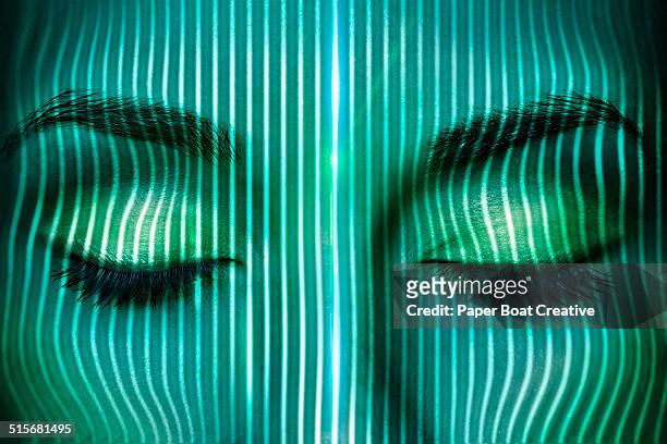 thin laser beams going over a woman's face - eye technology stock-fotos und bilder