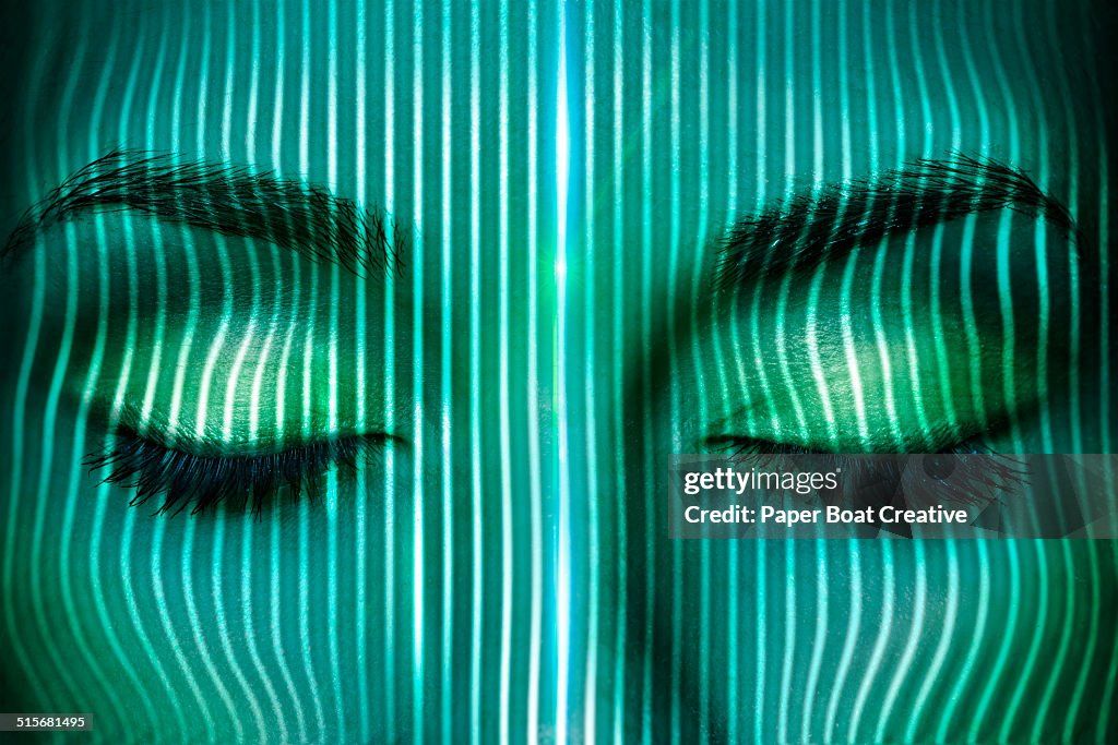 Thin laser beams going over a woman's face