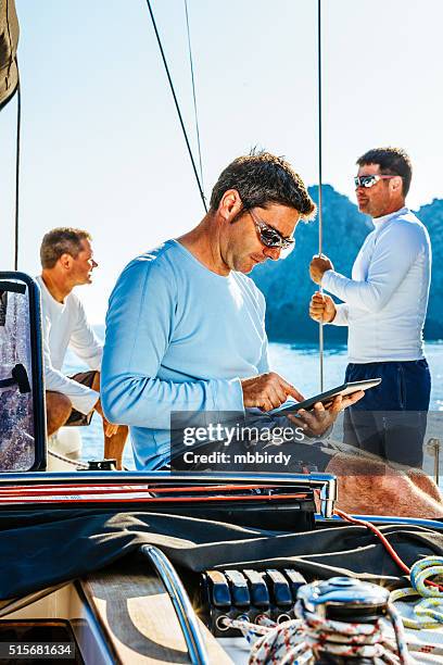 sailor using digital tablet on sailboat - yacht club stock pictures, royalty-free photos & images