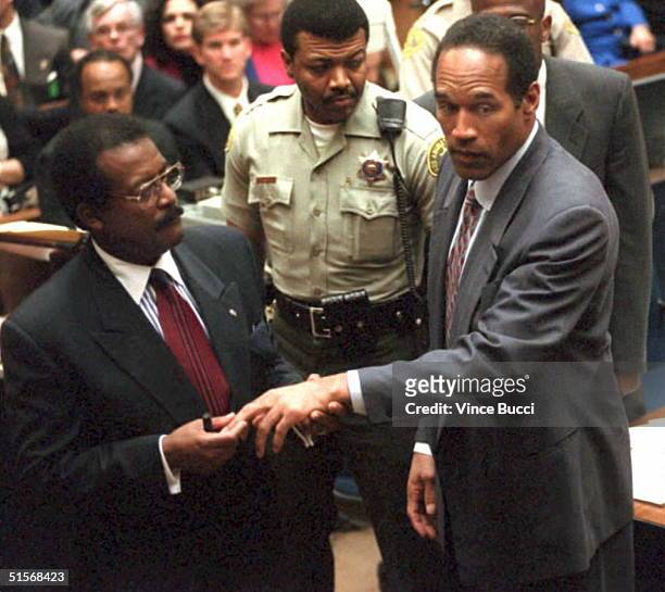 Defense attorney Johnnie Cochran, Jr. Shows the jury the cut on murder defendant O.J. Simpson's finger 25 January 1995 that the prosecution contends...