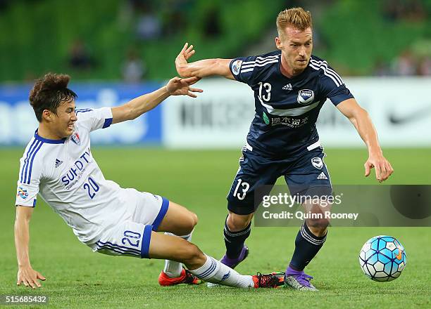 Oliver Bozanic of the Victory is tackled by Baek Jihoon of Suwon during the AFC Champions League match between the Melbourne Victory and Suwon...