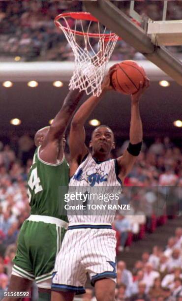 Orlando Magic guard Anfernee Hardaway draws a foul from Boston Celtics forward Xavier McDaniel as he slam dunks a basket during the first period of...