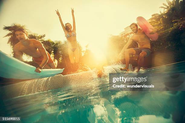 friends jumping in swimming pool - women swimming pool retro stock pictures, royalty-free photos & images