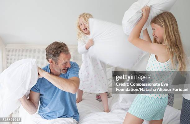 family pillow fighting in bedroom - lucha con almohada fotografías e imágenes de stock