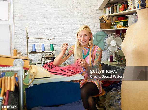 woman repairing dress in vintage clothes shop. - mannequin arm stock pictures, royalty-free photos & images