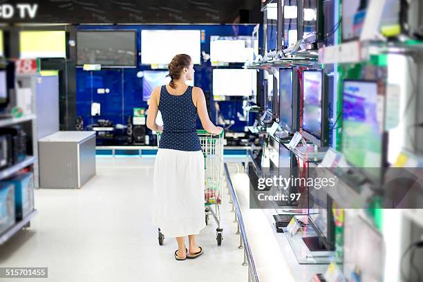 woman chooses a tv in the store - electrical engineering stockfoto's en -beelden