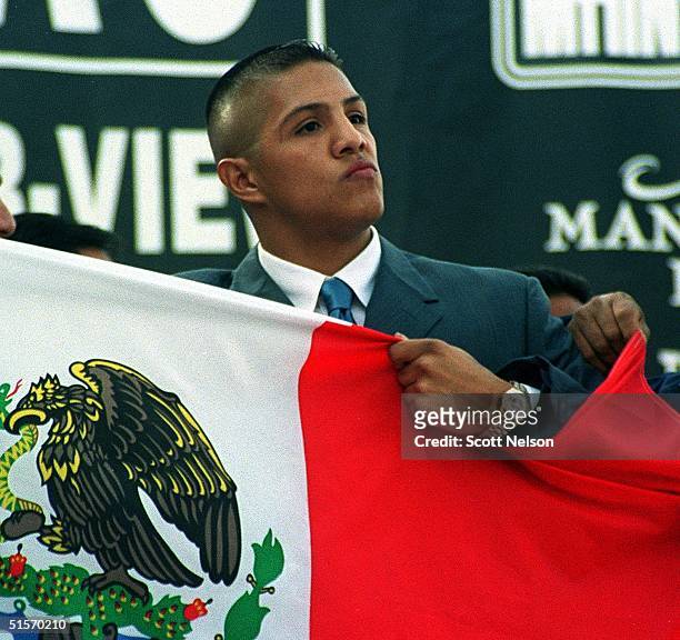 Mexican boxer and IBF Jr. Middleweight Champ Fernando Vargas clutches a Mexican flag during a 26 November 2000 press conference in Los Angeles, CA to...
