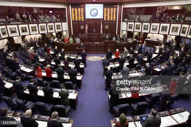 Members of the Florida House bow their heads in prayer at the opening of the historic special session of the Florida State Legislature to elect their...