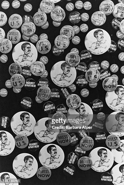 Selction of badges on display at an anti apartheid protest at Columbia University, New York City, 4th April 1984. The anti apartheid badges have the...