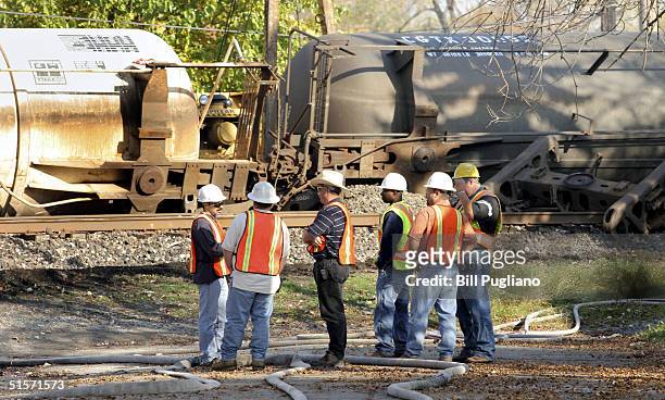 Workers clean up a seven-car Canadian National Railway train derailment October 24, 2004 in Detroit, Michigan. The derailment was declared a level 3...