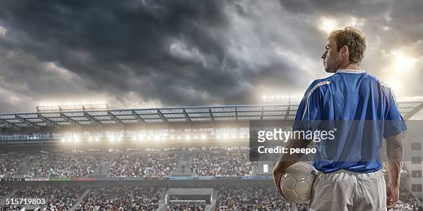 male soccer player standing in front of a large crowd - football jersey stock pictures, royalty-free photos & images
