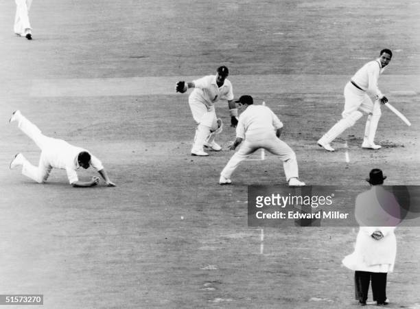 England cricketer Colin Cowdrey goes down to field a shot from Gary Sobers off a ball from Lock jn the final test match against the West Indies at...