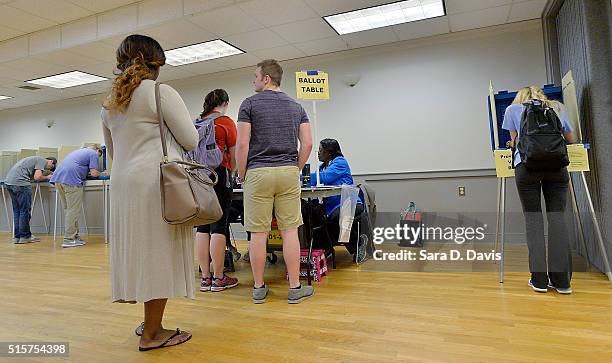 Lone North Carolina State University student, right, votes in the primaries at the provisional ballot booth at Pullen Community Center on March 15,...