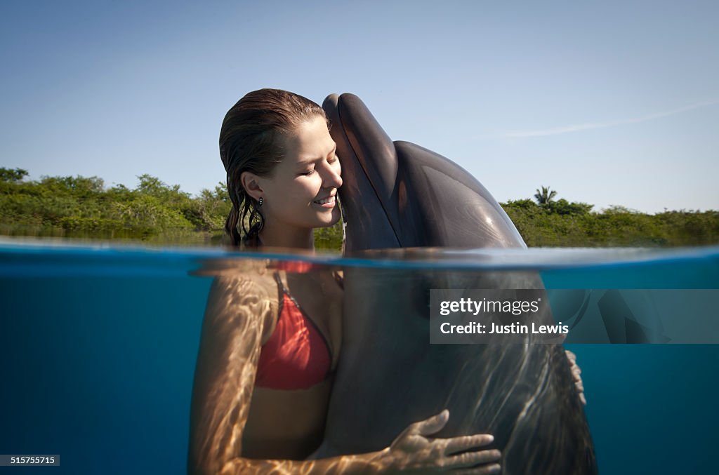 Young Girl with Dolphin Heads Above Water