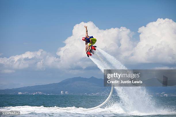 guy airboarding pacific ocean, mountains in backgr - sport acquatico foto e immagini stock