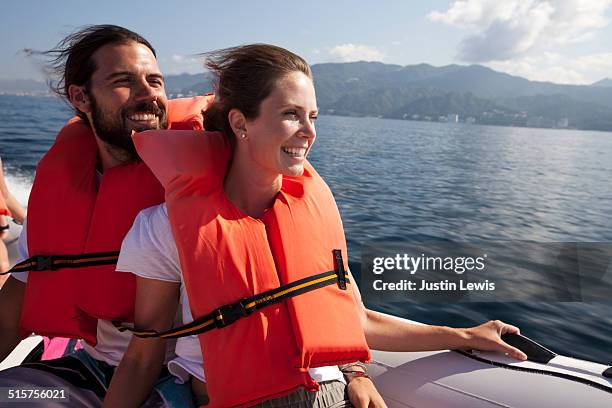 multicultural couple exploring ocean in speed boat - speed boat stock pictures, royalty-free photos & images