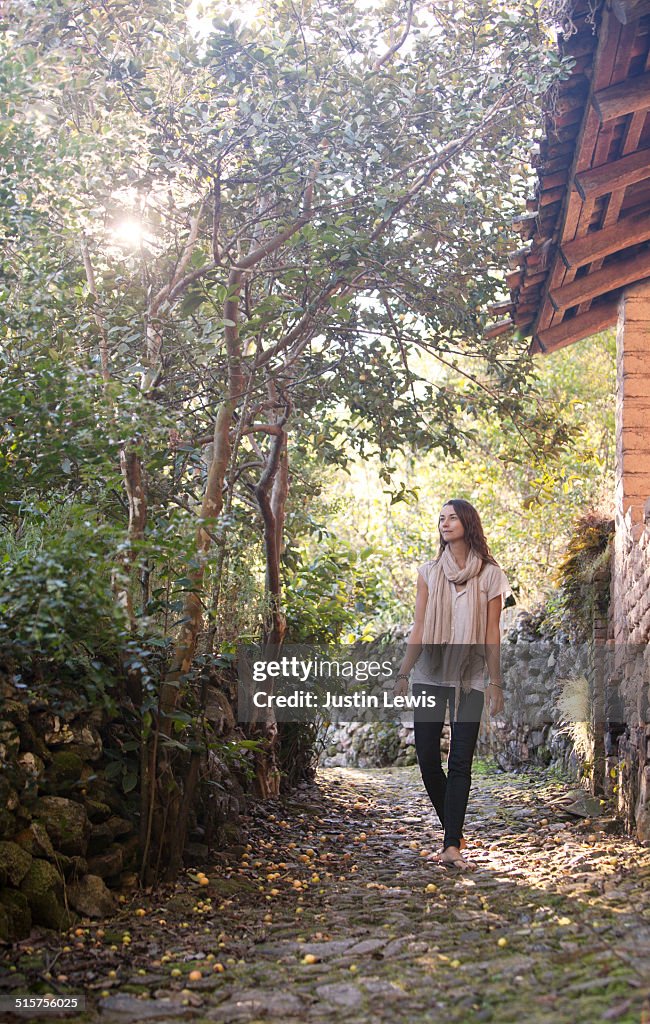 Young Woman Walking on Stone Pathway