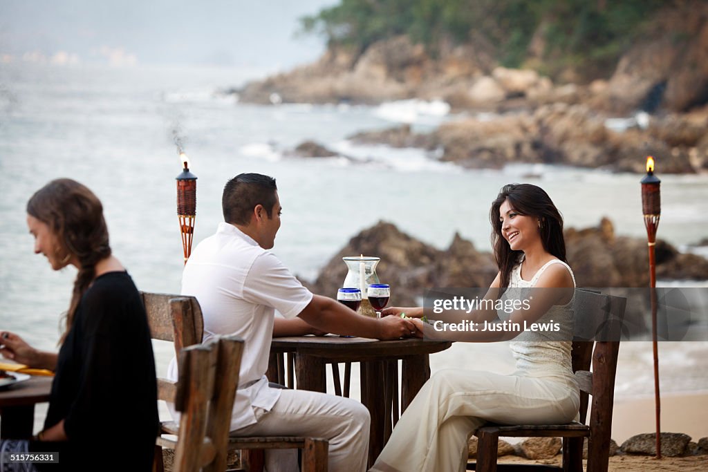 Hispanic Honeymoon Couple at Beachside Restaurant