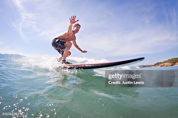 young man catches first wave surfing - man surfing photos et images de collection