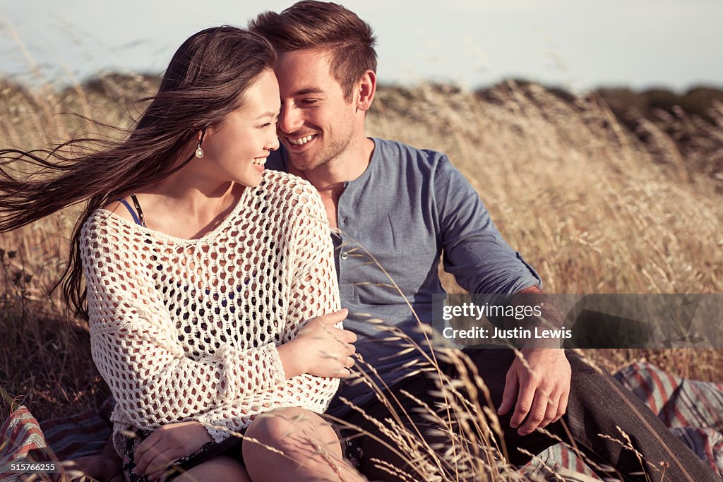 Closeup young couple grassy hillside smiling