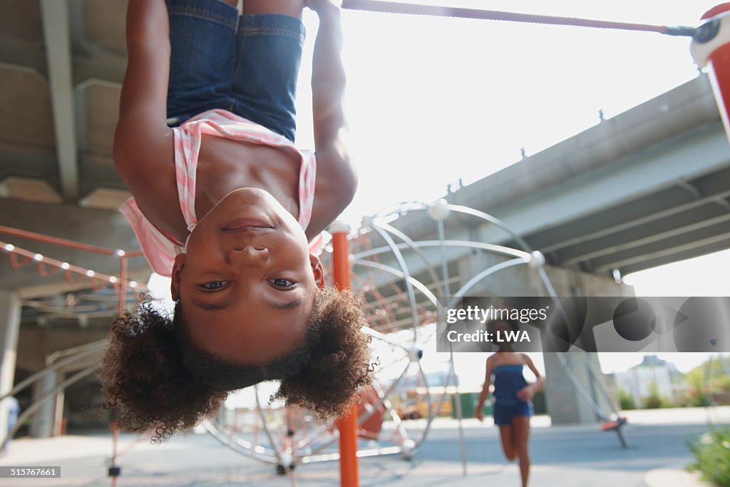 Young girl hanging upside down