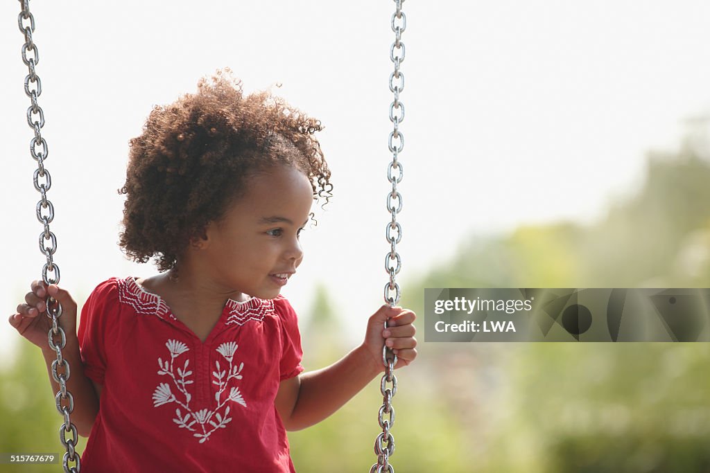 Young girl sitting on swing