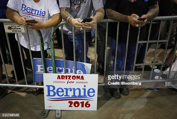 Attendees check their mobile devices before a campaign event for Senator Bernie Sanders, an independent from Vermont and 2016 Democratic presidential...