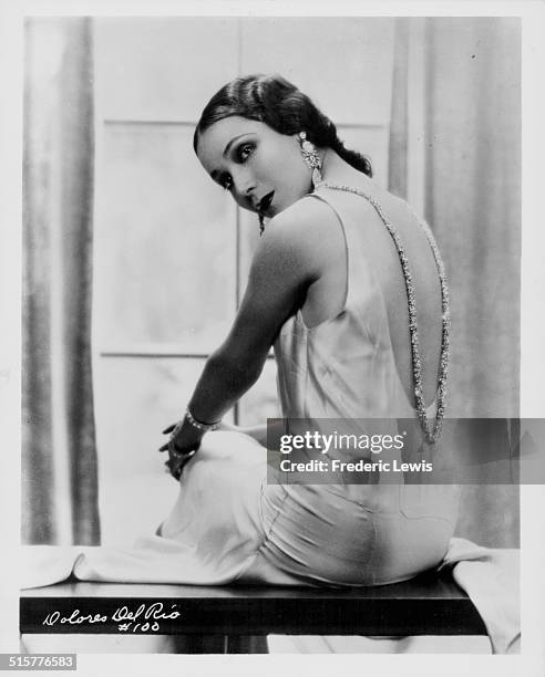Portrait of actress Dolores del Rio, wearing a silk evening dress with her back to camera, circa 1930.