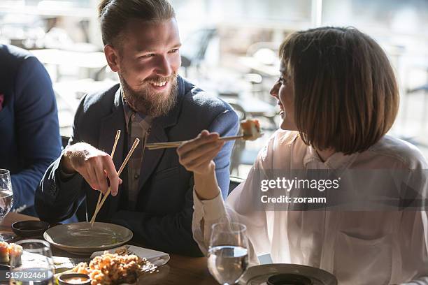 friends eating sushi - sushi stock pictures, royalty-free photos & images