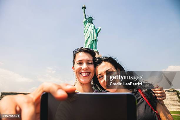 taking a selfie in front of statue of liberty - new york tourist stockfoto's en -beelden