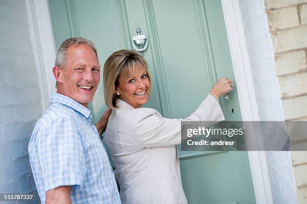 un couple arrivant à la maison - knocking photos et images de collection