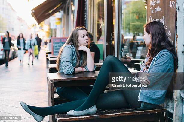 duas jovens mulheres sentadas em kreuzberg, em berlim, café de calçada - kreuzberg - fotografias e filmes do acervo