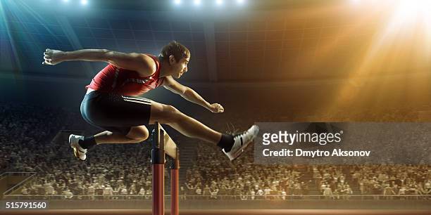 männliche athlet hürdenlauf auf rennen - hurdles stock-fotos und bilder