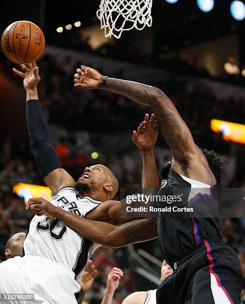 David West of the San Antonio Spurs grabs a rebound next to DeAndre Jordan of the Los Angeles Clippers at AT&T Center on March 15, 2016 in San...