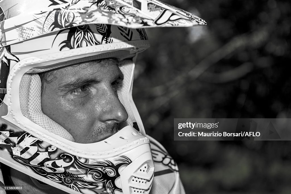 Young Man Relaxing Besides Motocross Bike in Countryside