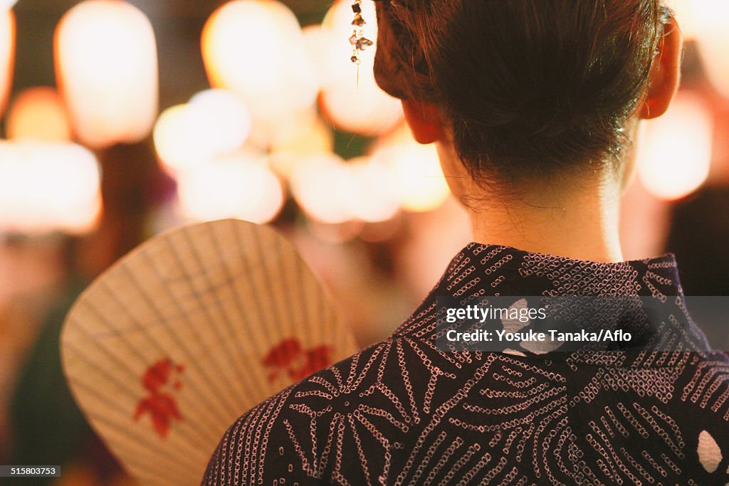 Young Japanese woman in a traditional kimono at a summer festival